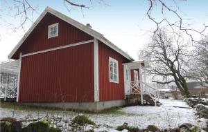 a red barn with snow on the ground at Gorgeous Home In Svsj With Kitchen in Sävsjö