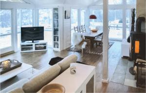 a living room with a couch and a television and a table at Lovely Home In Stranda With House A Mountain View in Stranda