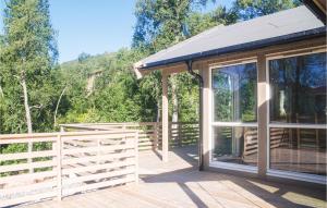 a house with a glass door on a wooden deck at Cozy Home In Stranda With Sauna in Stranda +12 photos