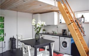 a kitchen with a table with a vase of flowers at 1 Bedroom Awesome Home In Vimmerby in Vimmerby