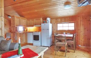 eine Küche mit einem weißen Kühlschrank und einem Tisch mit Stühlen in der Unterkunft Cozy Home In Ringebu With Kitchen in Ringebu