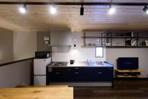 a kitchen with a stove and a white refrigerator at Rakuten STAY HOUSE x WILL STYLE Sasebo 101 in Sasebo
