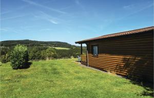 ゲロルシュタインにある2 Bedroom Cozy Home In Gerolsteinの建物の隣に芝生の庭があるログキャビン