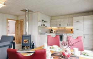 a kitchen with a table with red chairs and a fireplace at Gorgeous Home In Zerpenschleuse With Kitchen in Zerpenschleuse