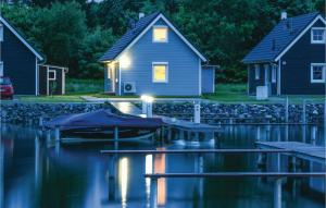 ein Haus mit einem Boot im Wasser bei Nacht in der Unterkunft 2 Bedroom Lovely Home In Zerpenschleuse in Zerpenschleuse