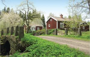 VimmerbyにあるBeautiful Home In Vimmerby With 1 Bedrooms And Wifiの赤い家の前の未舗装道路