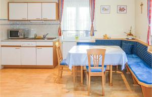 eine Küche mit einem Tisch, Stühlen und einem Waschbecken in der Unterkunft Beautiful Home In Loipersdorf-kitzladen With Outdoor Swimming Pool in Kitzladen
