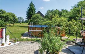 Kitzladen的住宿－Stunning Home In Loipersdorf-kitzladen With House A Panoramic View，花园内设有一个游乐场,后方有树木