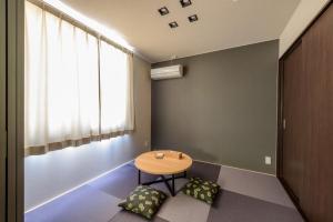 Rakuten STAY HOUSE x WILL STYLE Sasebo 103 في ساسيبو: طاولة صغيرة في غرفة مع نافذة