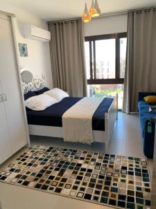 a bedroom with a bed with a checkered floor at Marassi Marina in El Alamein