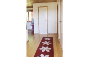 - un couloir avec un tapis rouge orné de fleurs blanches dans l'établissement Cozy Home In Nossebro With Kitchen, à Lekåsa