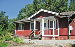 una pequeña casa roja con porche y entrada en Cozy Home In Nossebro With Kitchen, en Lekåsa