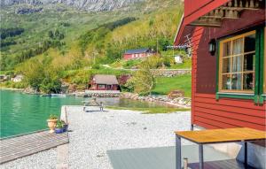 a red house with a view of a lake at 2 Bedroom Lovely Home In Hyllestad in Hovland