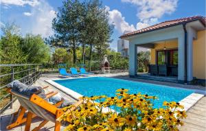 a pool with chairs and flowers in front of a house at Beautiful Home In Gostinjac With Outdoor Swimming Pool in Gostinjac