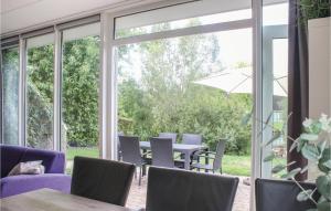 a patio with a table and chairs and a large window at Awesome Home In Vlagtwedde With Wifi in Vlagtwedde
