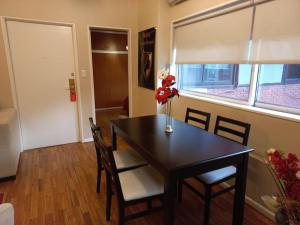 a dining room table with chairs and a vase with flowers at Departamento de Gaby en Retiro in Buenos Aires