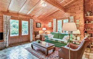Cabaña de madera con sala de estar con sofá verde y mesa en Cozy Home In Meijel With Wifi, en Meijel
