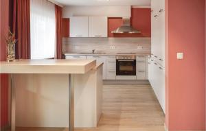 a kitchen with white cabinets and red walls at Stunning Apartment In Bllingen With Kitchen in Bullange