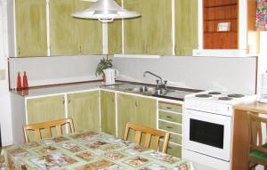 a kitchen with a sink and a table with chairs at Beautiful Home In Torup With House Sea View in Ynnabo