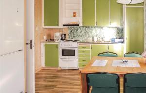 FegenにあるHarenのキッチン(緑のキャビネット、テーブル、椅子付)