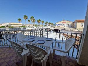 einen Tisch und Stühle auf einem Balkon mit Blick auf den Strand in der Unterkunft Studio Marseillan-Plage, 1 pièce, 4 personnes - FR-1-326-769 in Marseillan