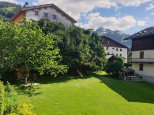 a green yard with trees and a building at Chalet cosy pour 2-3 pers. avec jardin au cœur du village, à 5 min du ski et proche des commerces - FR-1-342-274 in Beaufort