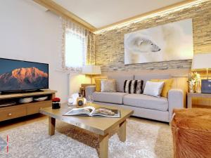 a living room with a couch and a tv at Appartement Courchevel 1550, 3 pièces, 4 personnes - FR-1-664-5 in Courchevel