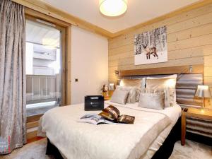 Un dormitorio con una cama con un libro. en Appartement Courchevel 1550, 3 pièces, 4 personnes - FR-1-664-5 en Courchevel