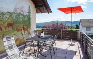 een patio met een tafel en stoelen en een parasol bij Nice Apartment In Jesberg - Densberg With Wifi in Densberg