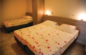 a bedroom with two beds with flowers on them at 1 Bedroom Lovely Home In Retranchement in Retranchement +7 photos