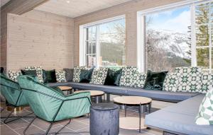 a porch with a blue couch and chairs and windows at Privatn in Hemsedal