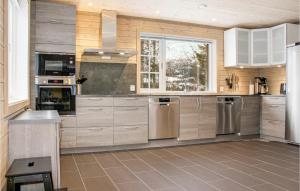 uma cozinha com armários brancos e electrodomésticos de aço inoxidável em Privatn em Hemsedal