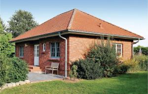 a brick house with a chair in front of it at Nice Home In Ahrenshagen Ot Tribohm With Kitchen in Tribohm