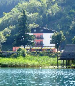 una casa sentada a un lado de un lago en Hotel Cima d'Oro, en Ledro