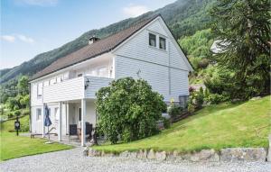 a white house on a hill with a mountain at Awesome Apartment In Bruvik With 2 Bedrooms And Wifi in Bruvik