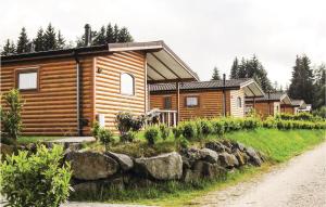 a log cabin with a rock wall in front of it at Lovely Home In Gerolstein With Wifi in Gerolstein