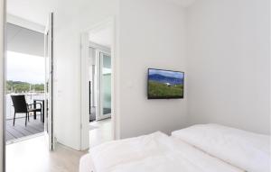 a white room with a bed and a tv on the wall at Promenadenvilla in Travemünde