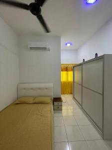 una camera con letto e ventilatore a soffitto di NORISH HOMESTAY a Bayan Lepas