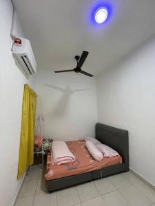 バヤンレパスにあるNORISH HOMESTAYのベッドルーム1室(ピンクの枕と天井ファン付きのベッド1台付)