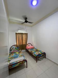 una camera con due letti e un soffitto di NORISH HOMESTAY a Bayan Lepas