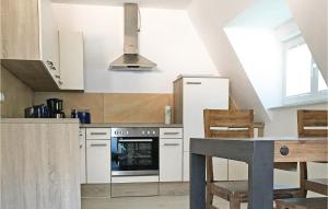 a kitchen with white cabinets and a table with chairs at Awesome Home In Loddin With 2 Bedrooms, Sauna And Wifi in Loddin