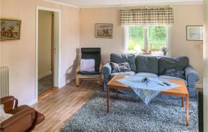 a living room with a blue couch and a table at Beautiful Home In Sjtofta With Kitchen in Hornbetan