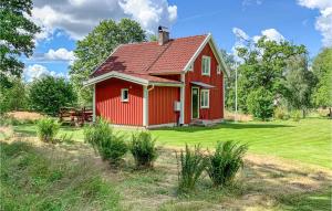 une maison rouge avec un toit rouge dans un champ dans l'établissement Beautiful Home In Sjtofta With Kitchen, à Hornbetan