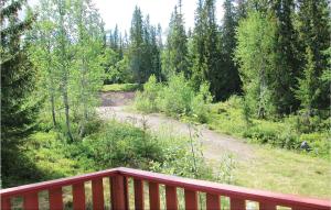 a wooden deck with a view of a forest at Nice Home In Sälen With Wifi in Våtkölssätern