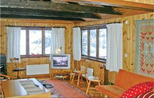 a living room with wooden walls and windows and a television at Nice Home In Slen With Wifi in Våtkölssätern