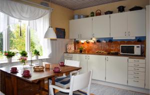 ムータラにある4 Bedroom Gorgeous Home In Motalaのキッチン(木製テーブル、白いキャビネット付)