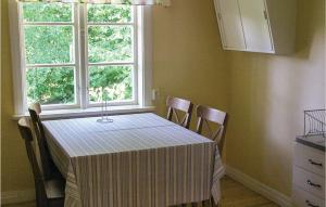 mesa de comedor con sillas y ventana en 1 Bedroom Cozy Home In Vimmerby, en Vimmerby