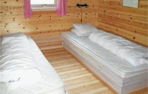 ØysteseにあるNice Home In ystese With House A Mountain Viewの木製の壁にベッド2台が備わる部屋