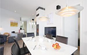 uma sala de jantar com uma mesa branca e cadeiras em Promenadenvilla em Priwall