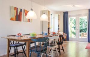 een keuken en eetkamer met een houten tafel en stoelen bij 3 Bedroom Awesome Home In Zonnemaire in Zonnemaire